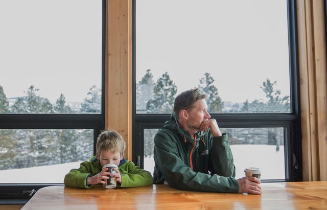 Father and son drinking hot chocolate at alpine cabin